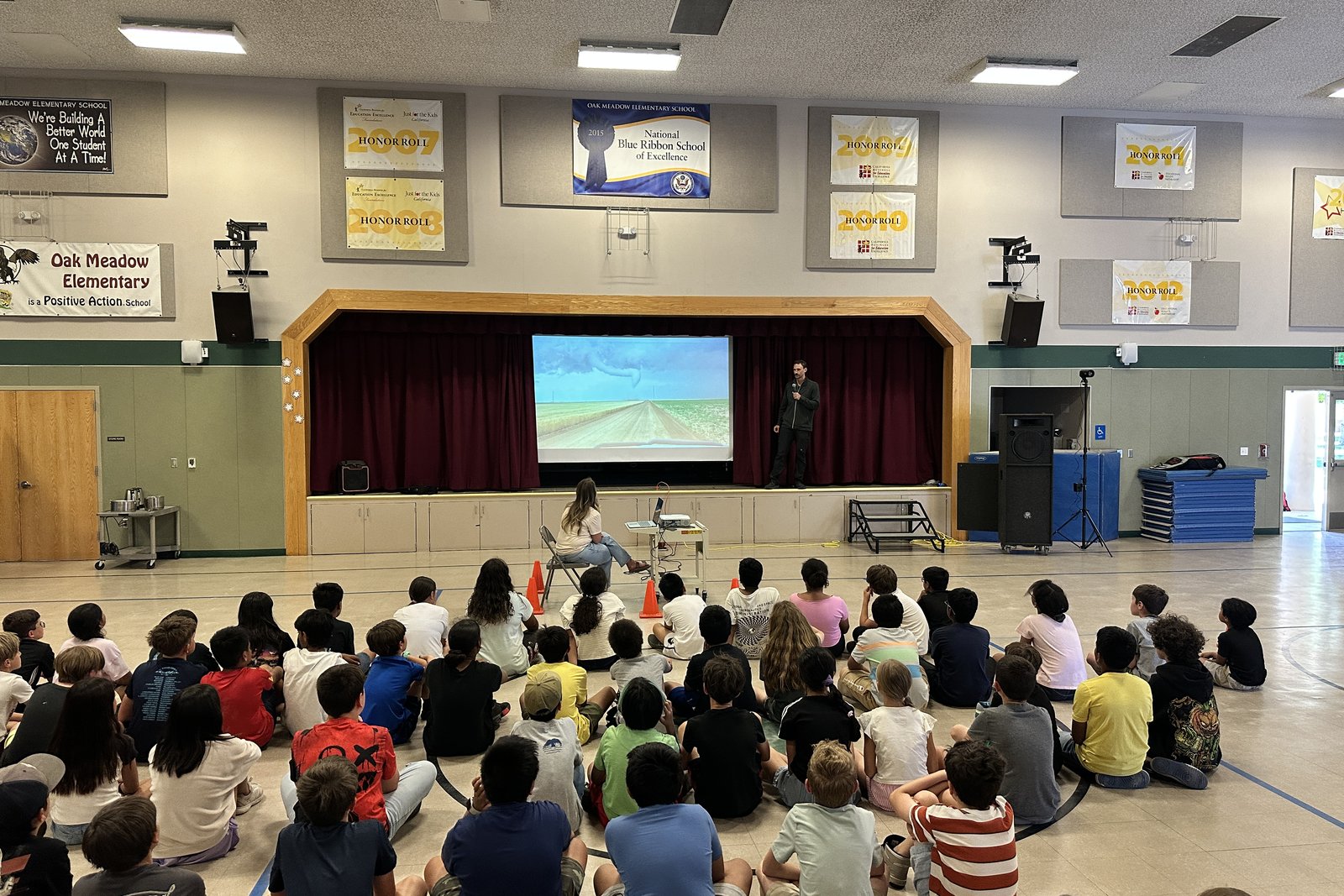 Students watching storm footage during a school assembly.